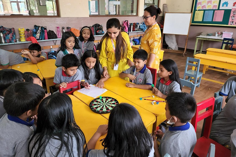 A teacher mentoring secondary students in a Nepali classroom